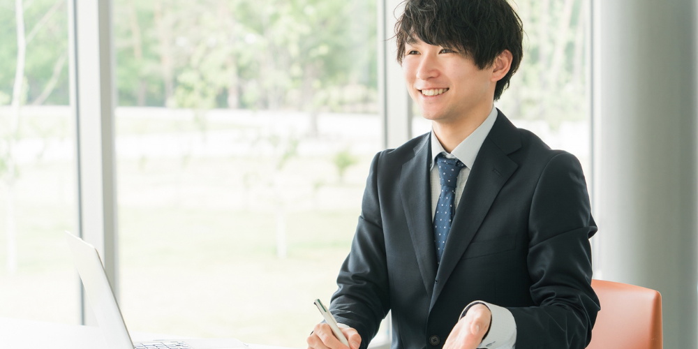 笑顔で相談を受けるスーツ姿の営業担当者