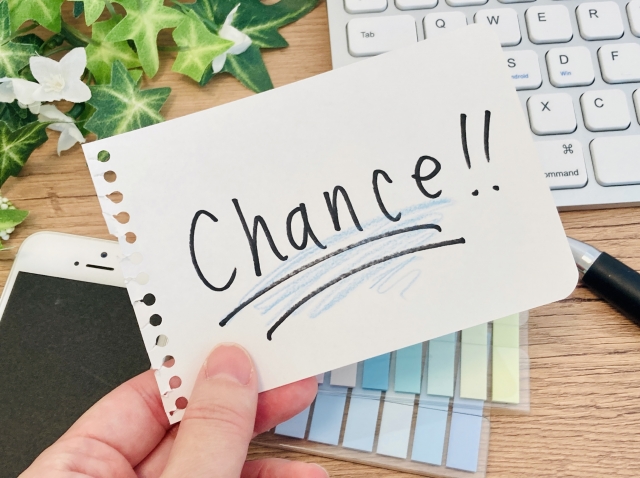 チャンスと書かれた紙を持つ手