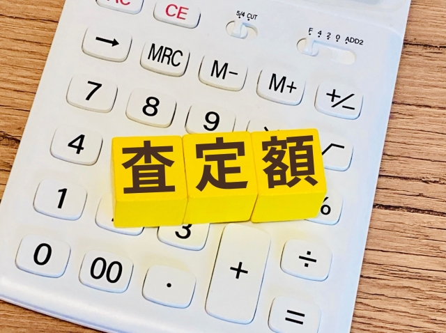 査定額と書かれたブロックと電卓